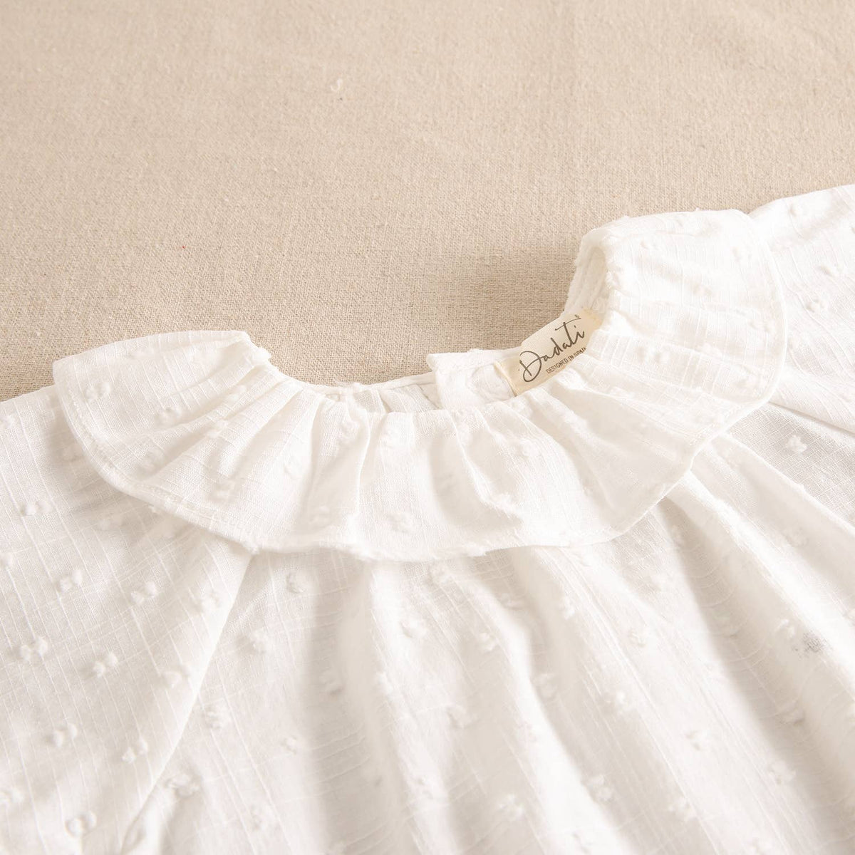 Blouse blanche en plumetis pour fille avec col volanté et manches courtes